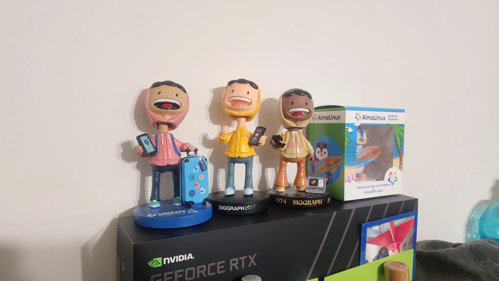 A row of colorful SIGGRAPH collectible figures displayed on an RTX box.